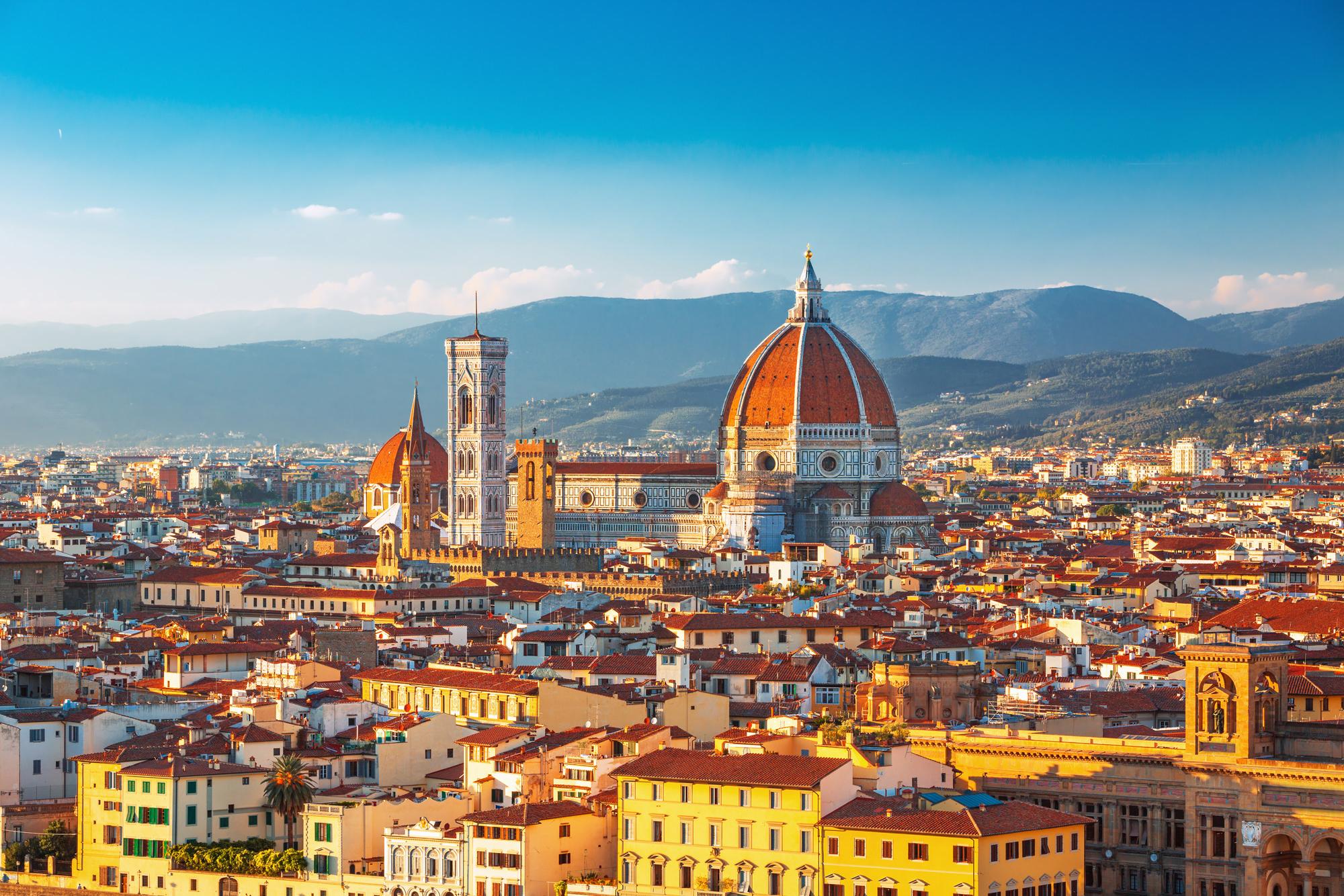 Blick über Florenz auf die Kathedrale Santa Maria del Fiore, im Hintergrund Berge