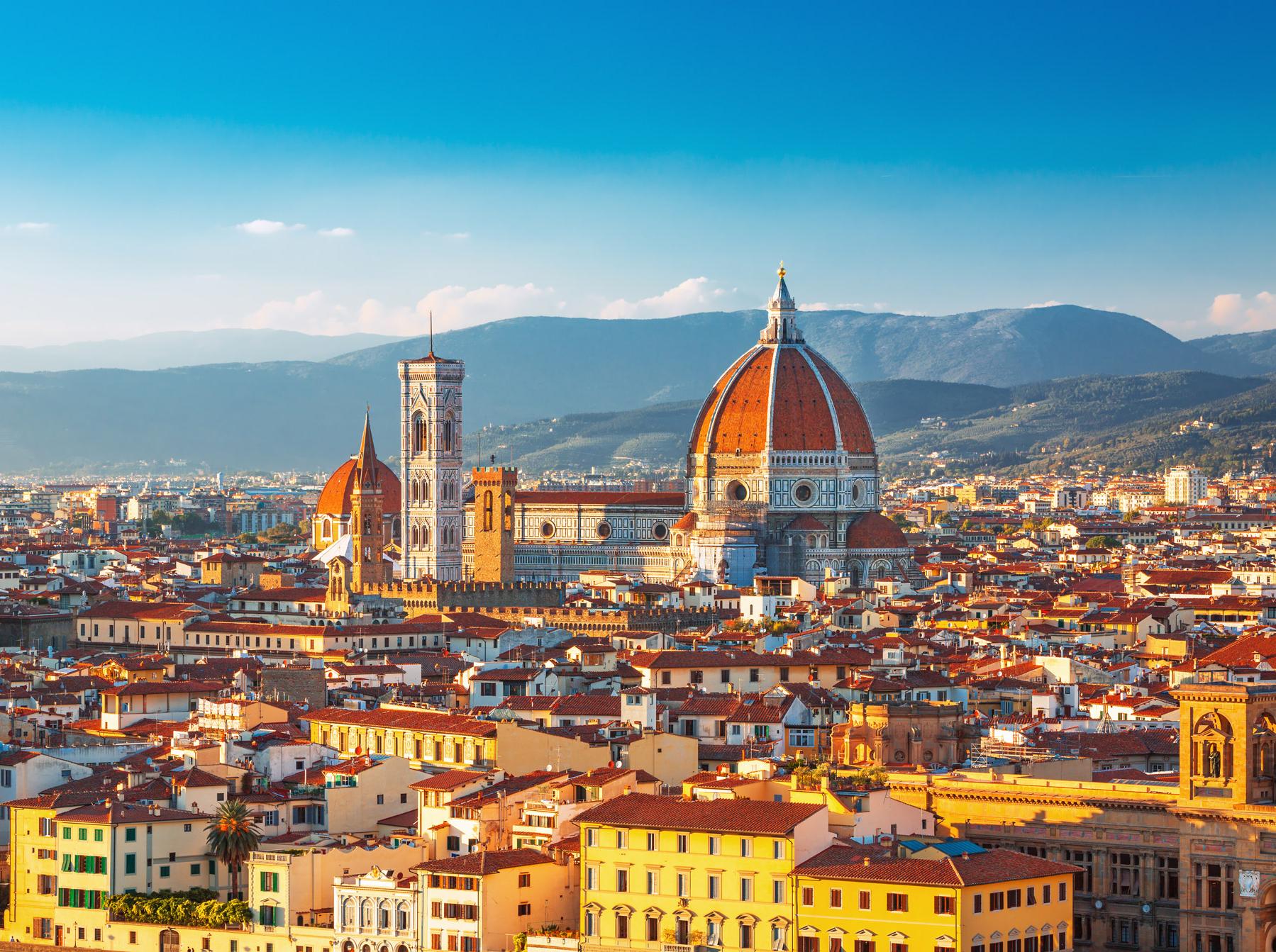Blick über Florenz auf die Kathedrale Santa Maria del Fiore, im Hintergrund Berge