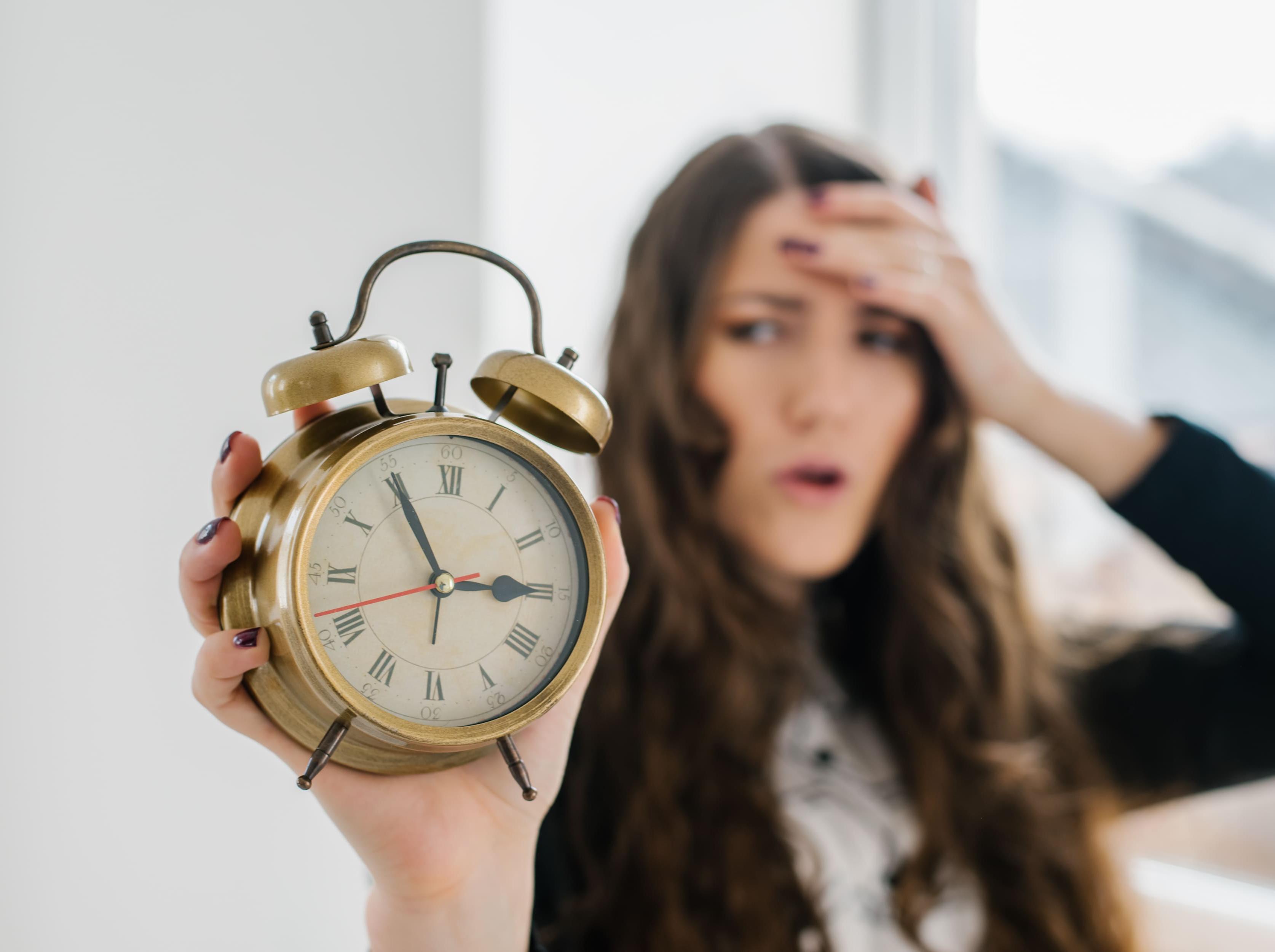 Frau mit Uhr in der Hand