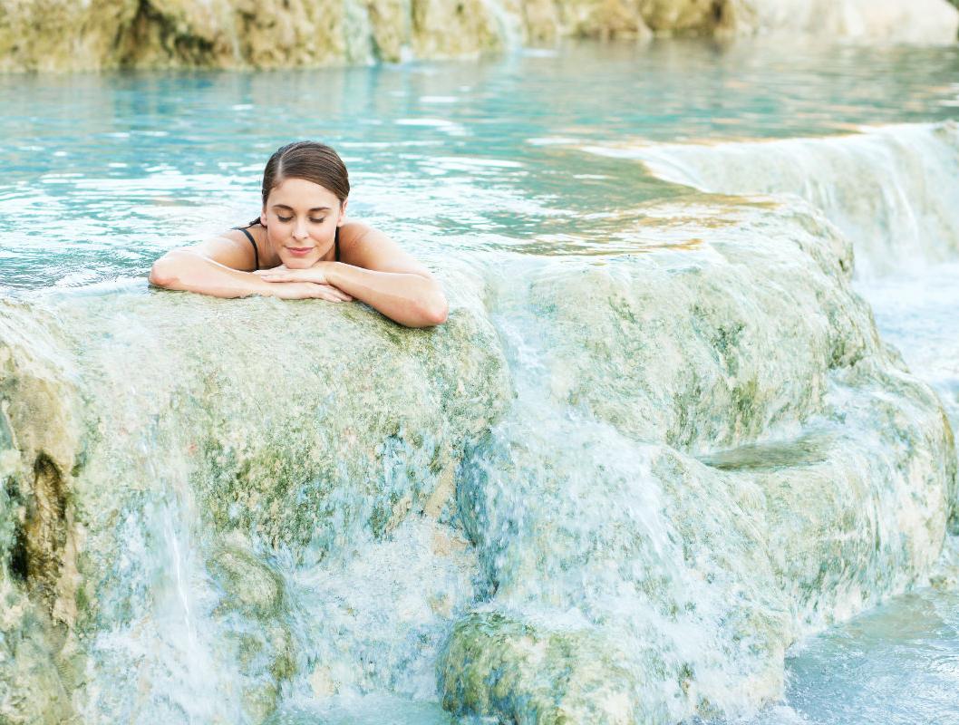 Frau entspannt in Thermalquelle in der Natur