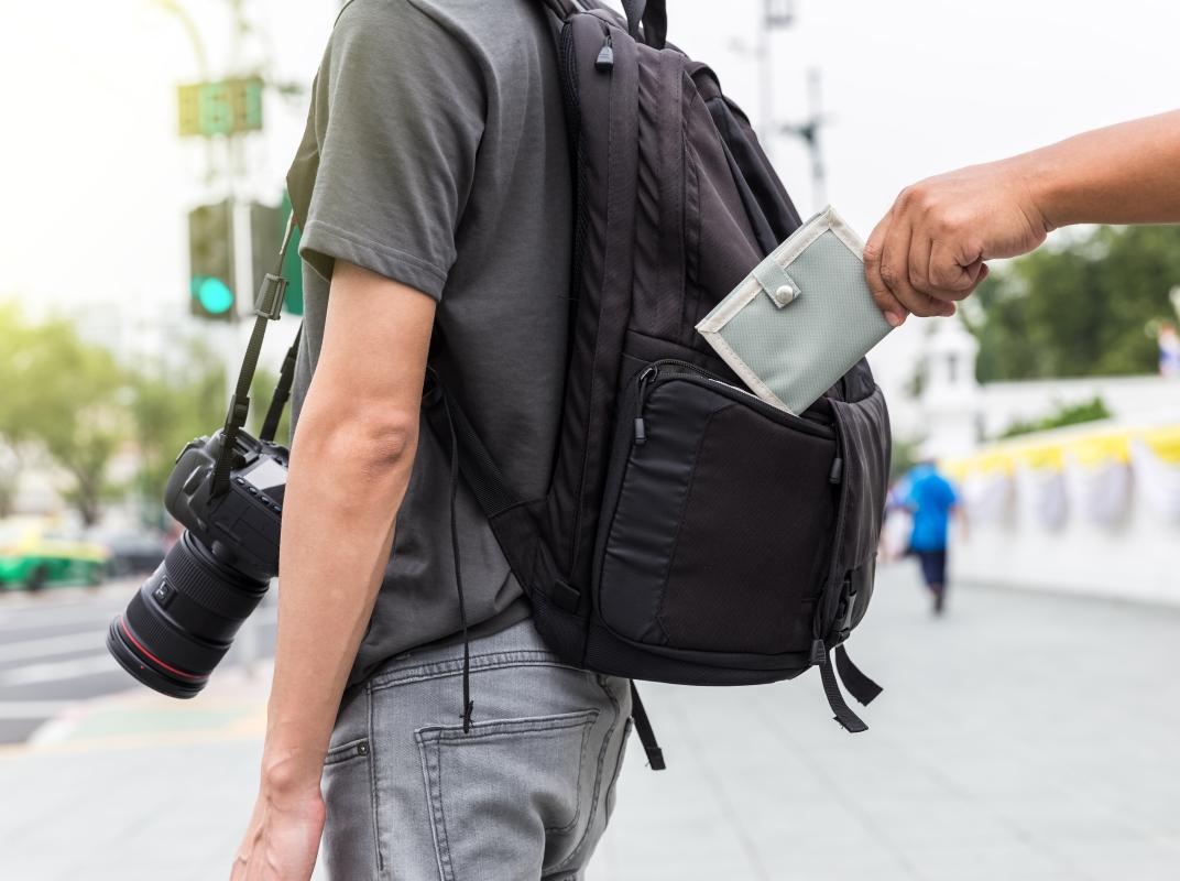 Hand klaut Geldbeutel aus Rucksack