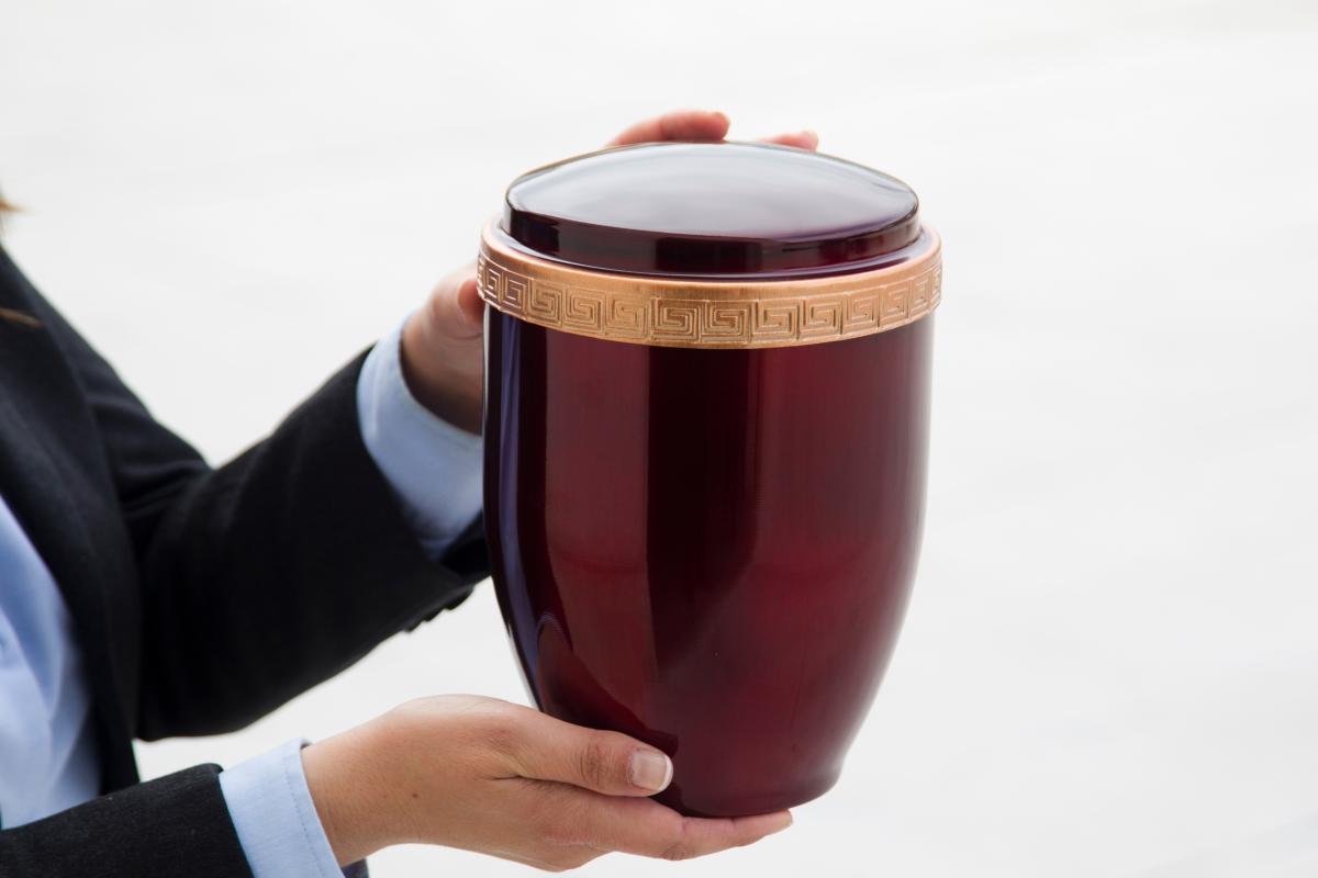 Urne, von zwei Händen gehalten