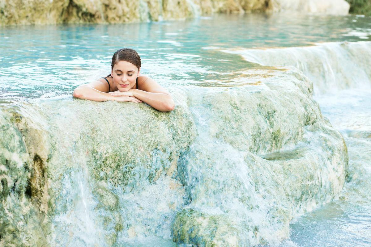 Frau entspannt in Thermalquelle in der Natur