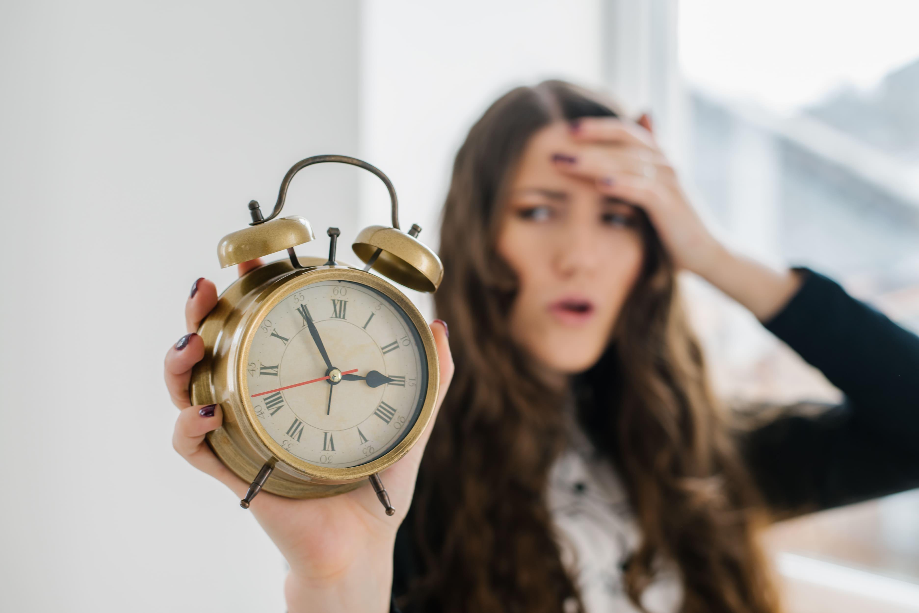 Frau mit Uhr in der Hand