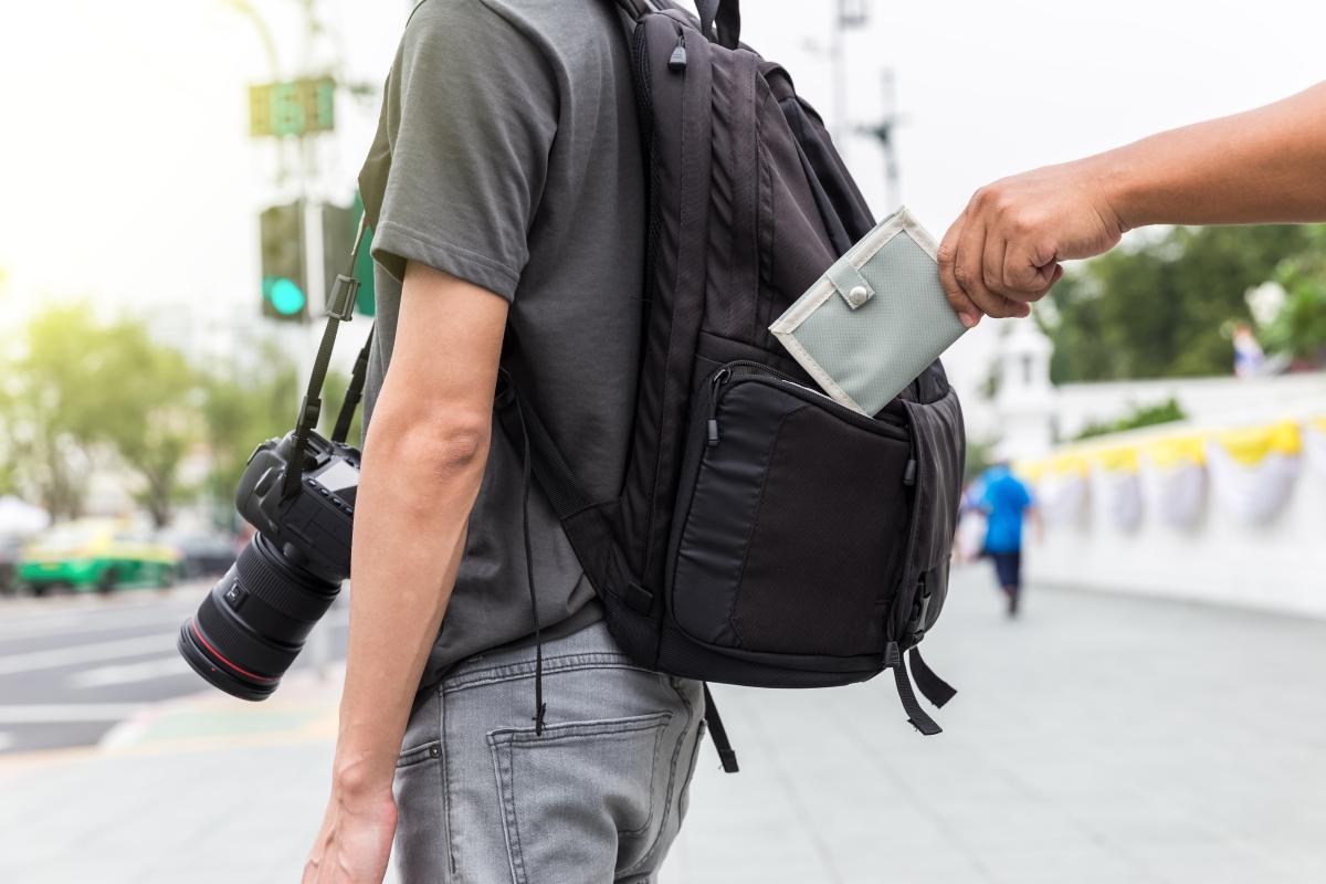 Hand klaut Geldbeutel aus Rucksack